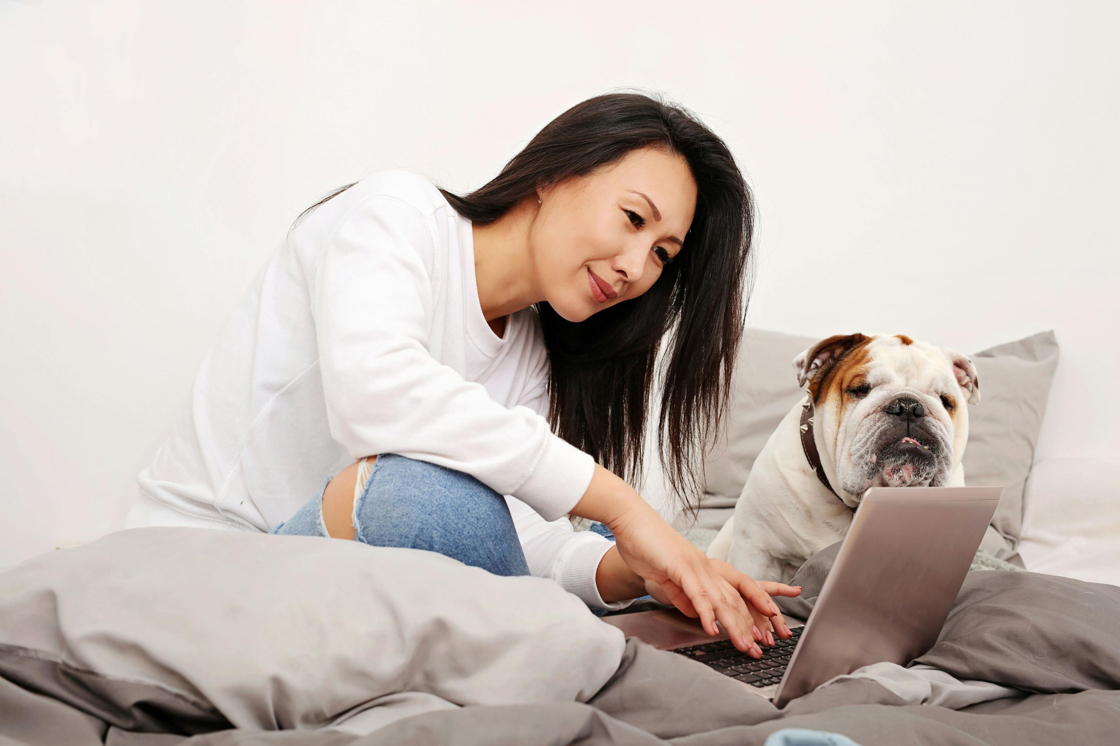 woman with her dog looking at a laptop