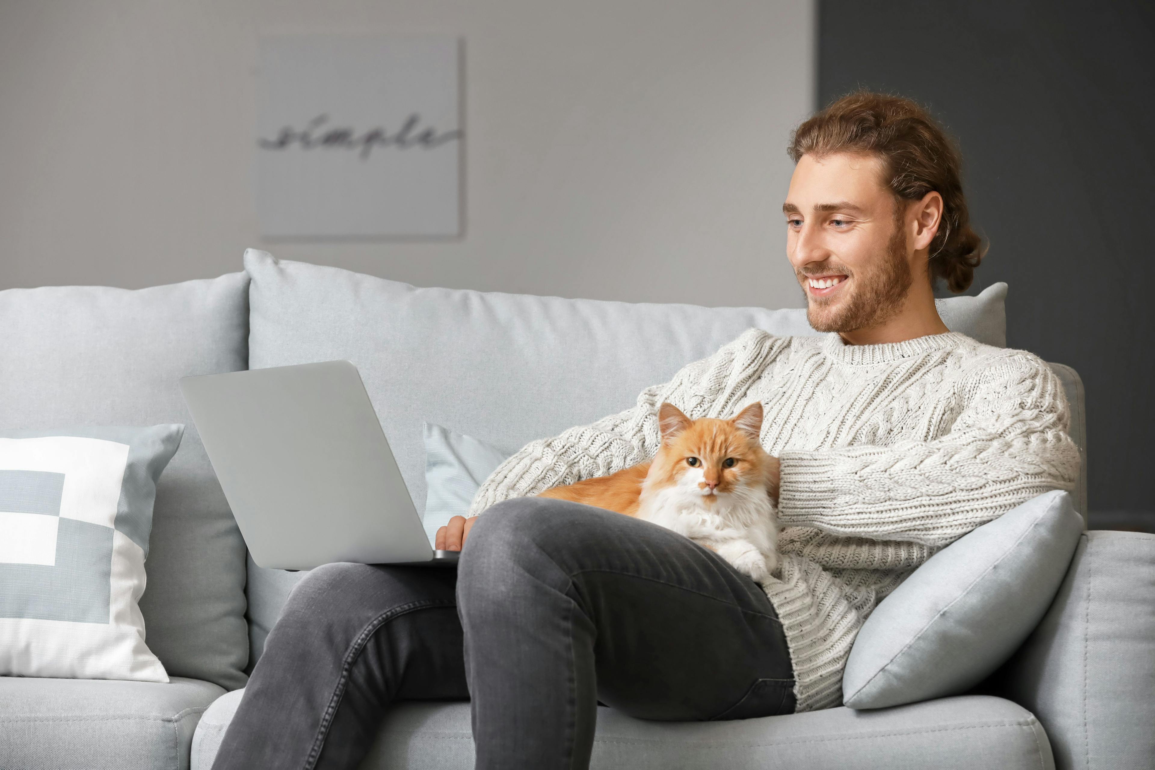 man with cat on computer