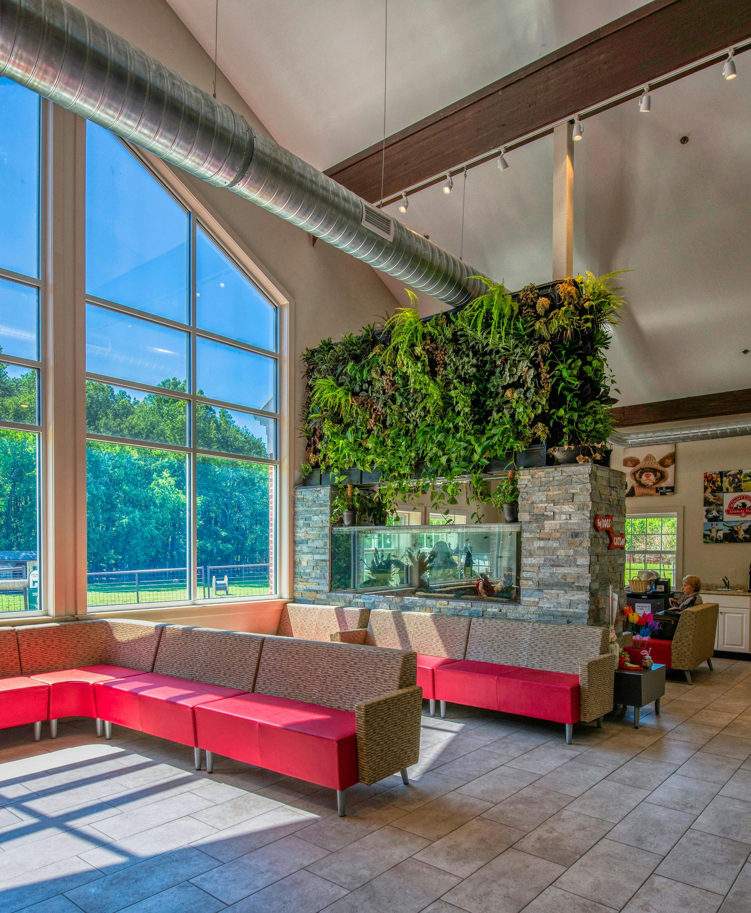 The lobby is spacious and welcoming, with large windows that let in natural light and overlook the farm and memorial pond. Many unique features pepper the reception area, including an aquarium, a turtle pond, a live green wall,and al ife like 30-foot rainforest tree. Neutral grays accented with pops of red are the color scheme throughout the hospital, with large canvas photos of clients’ and staff members’ pets gracing the walls.

