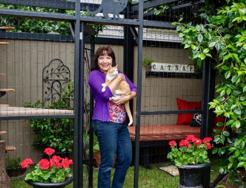 Cynthia Chomos, founder and DIY designer at Catio Spaces, with a feline friend (All images photo courtesy of Catio Spaces). 