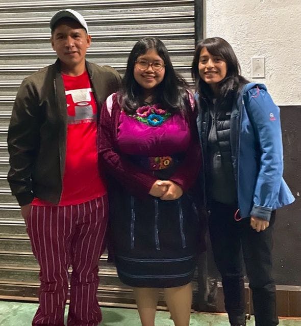 From left, Andrés, Cristina, and Lopez take a group photo on the last day of the campaign in Todos Santos. Cristina is wearing traditional clothing and Andrés is wearing traditional pants.