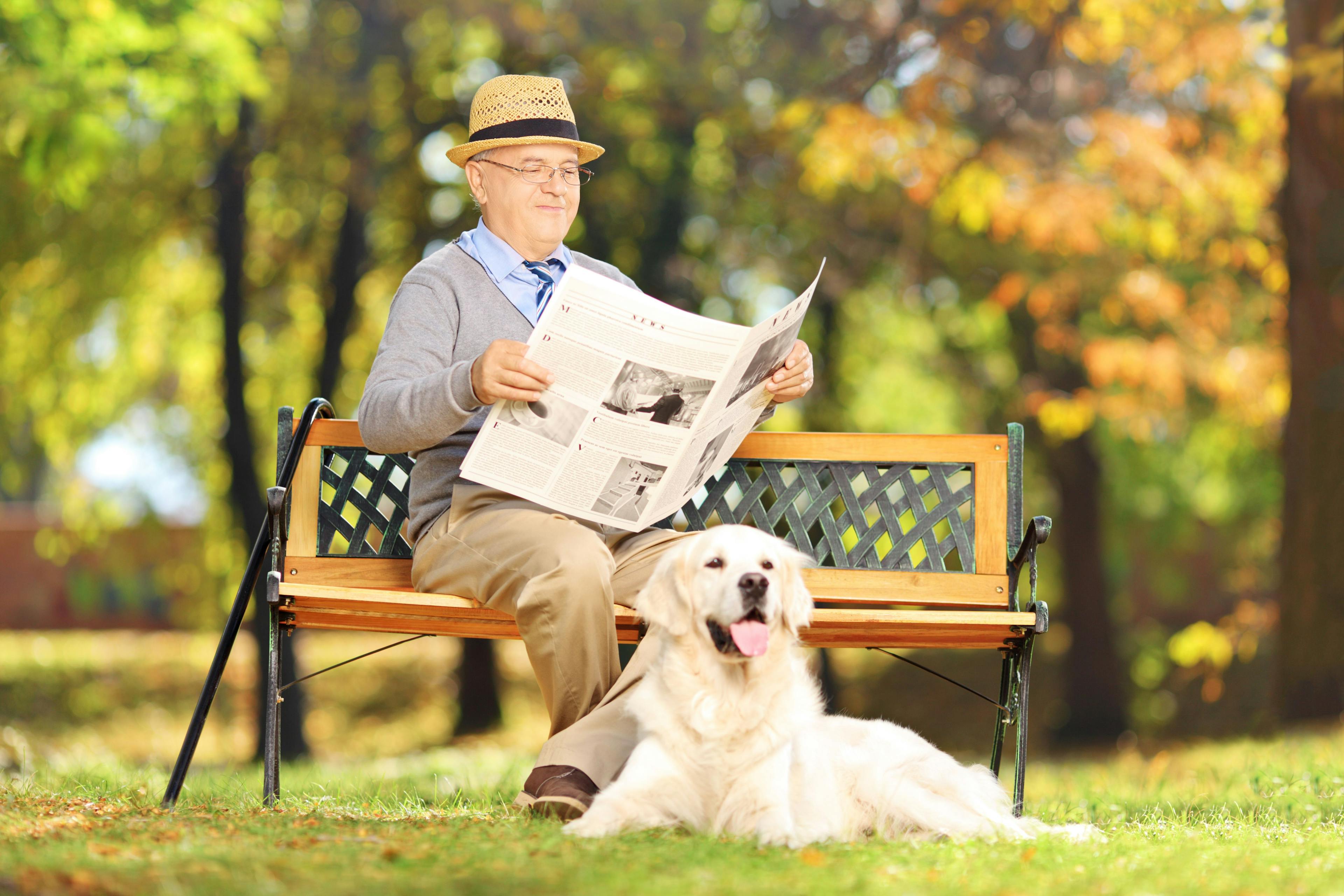 man reading newspaper with dog