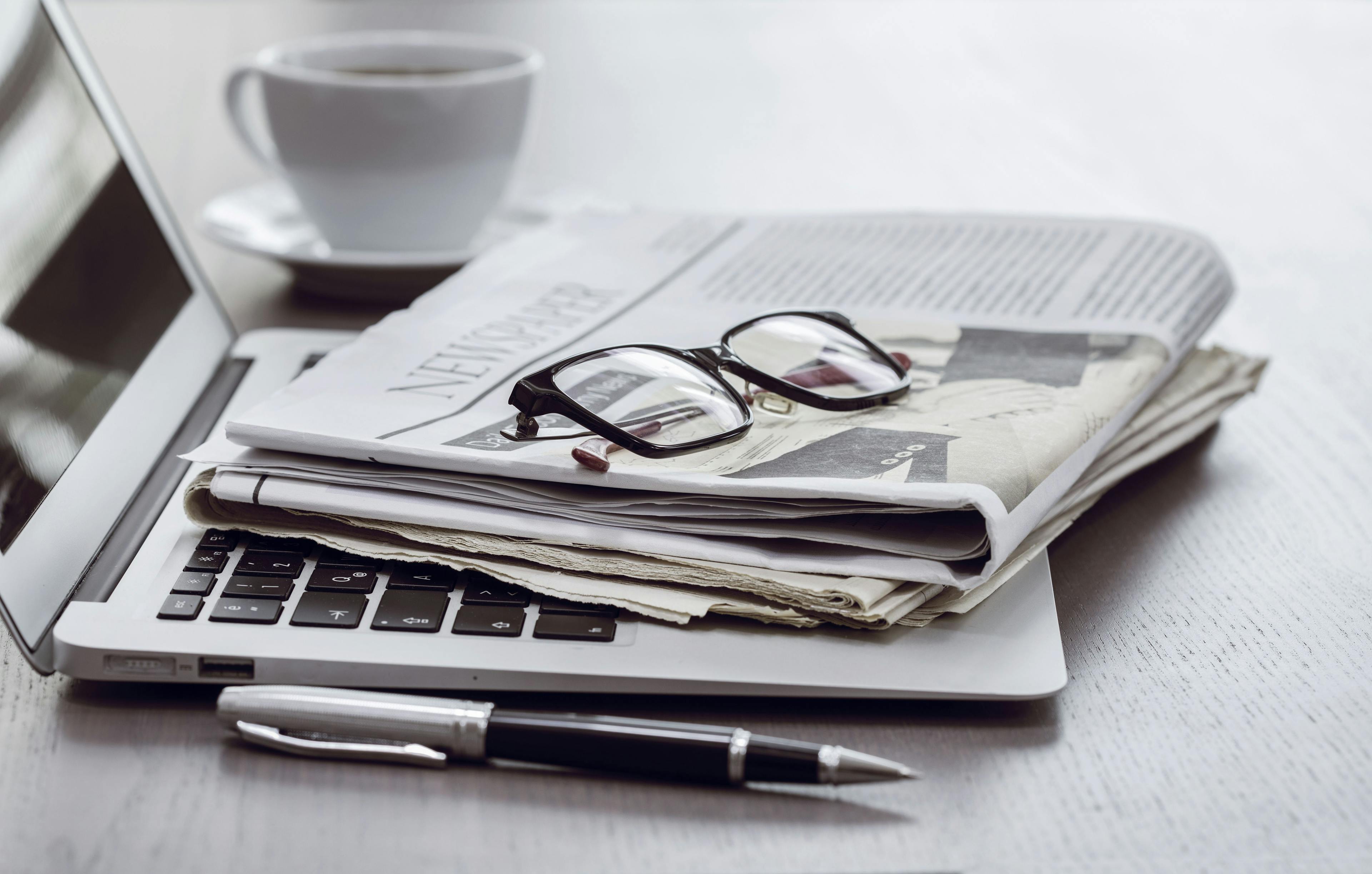 newspaper and glasses and pen