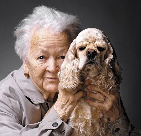 veterinary-close-up-portrait-of-an-old-woman-with-american-spaniel-on-a-gray-background-450px-shutterstock-122762662.jpg