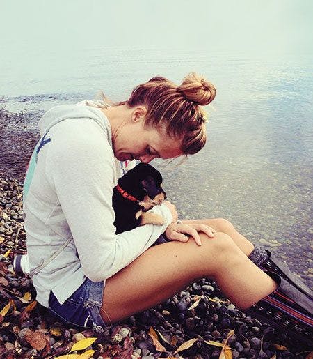 girl with dog near lake.