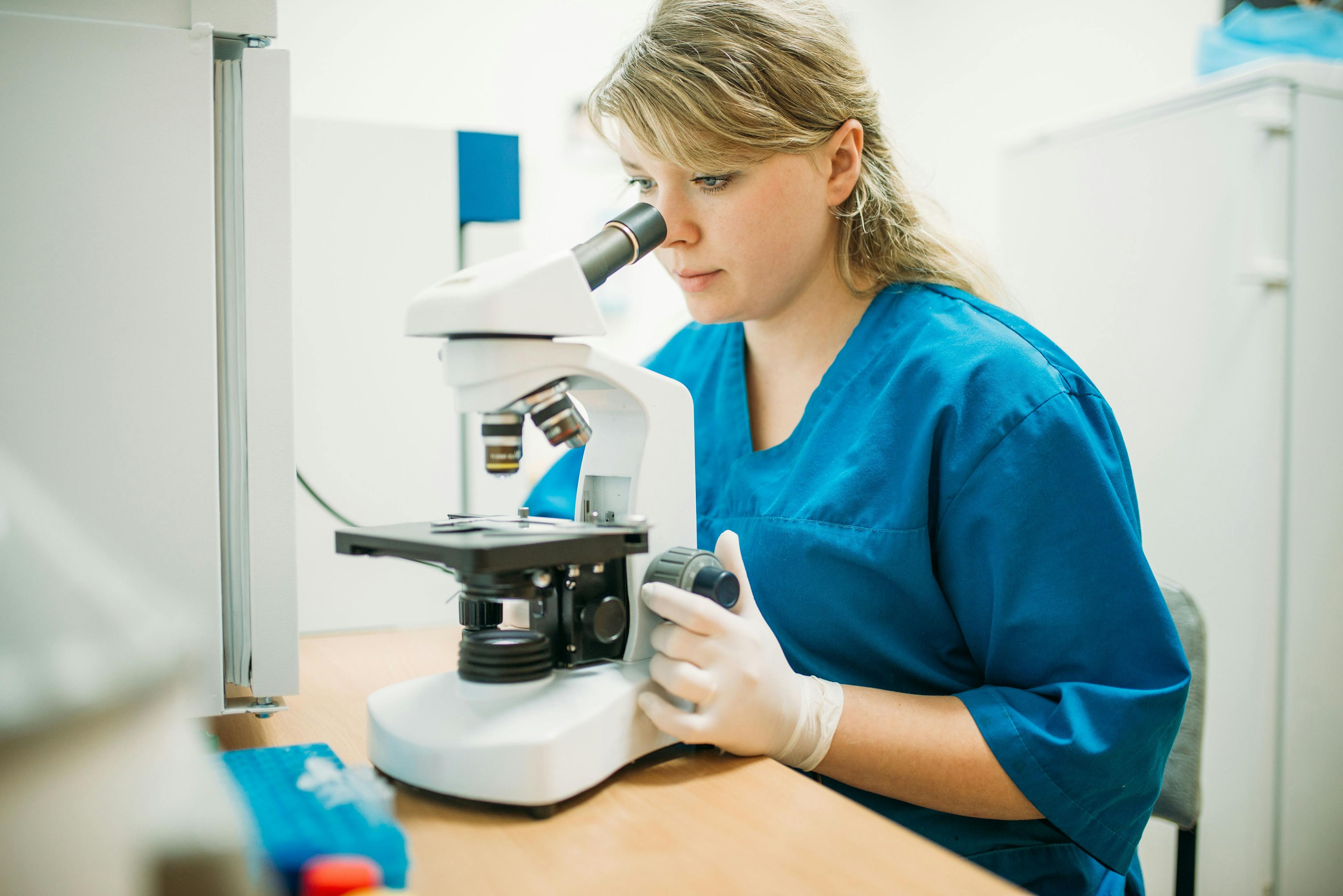 veterinarian looking through microscope