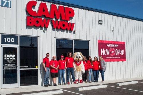 Camp Bow Wow staff posing in front of the newest location (Photo courtesy of Camp Bow Wow). 